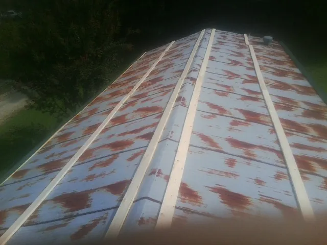 Rusted metal roof panels with new wood purlins before replacement — Storm Damage Roof Repair in Saint Louisville by Roofing Brothers