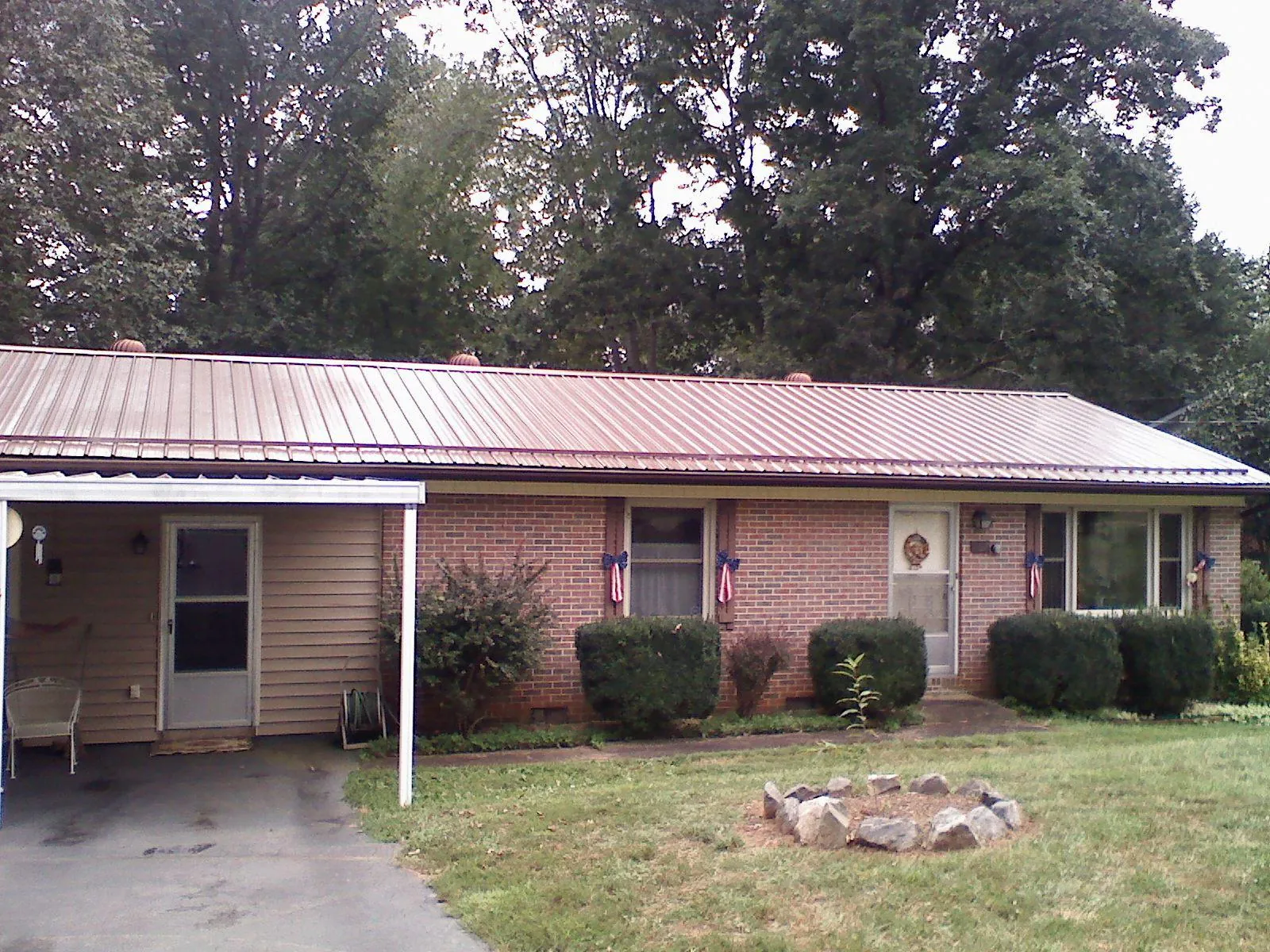 Bronze metal roof and carport on a brick ranch home — Roof Repair work by our crew in Saint Louisville
